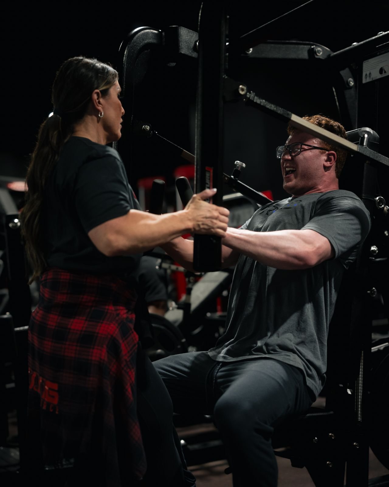 Coach guiding an athlete through a strength exercise