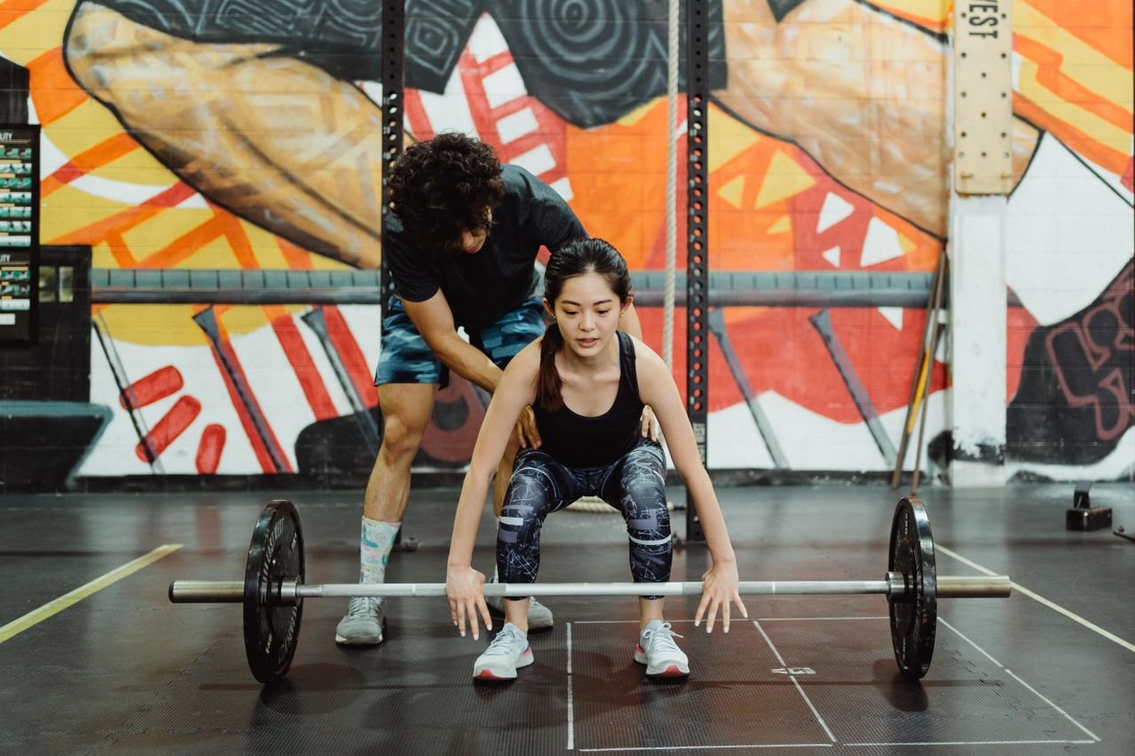 Coach refining an athlete's barbell technique